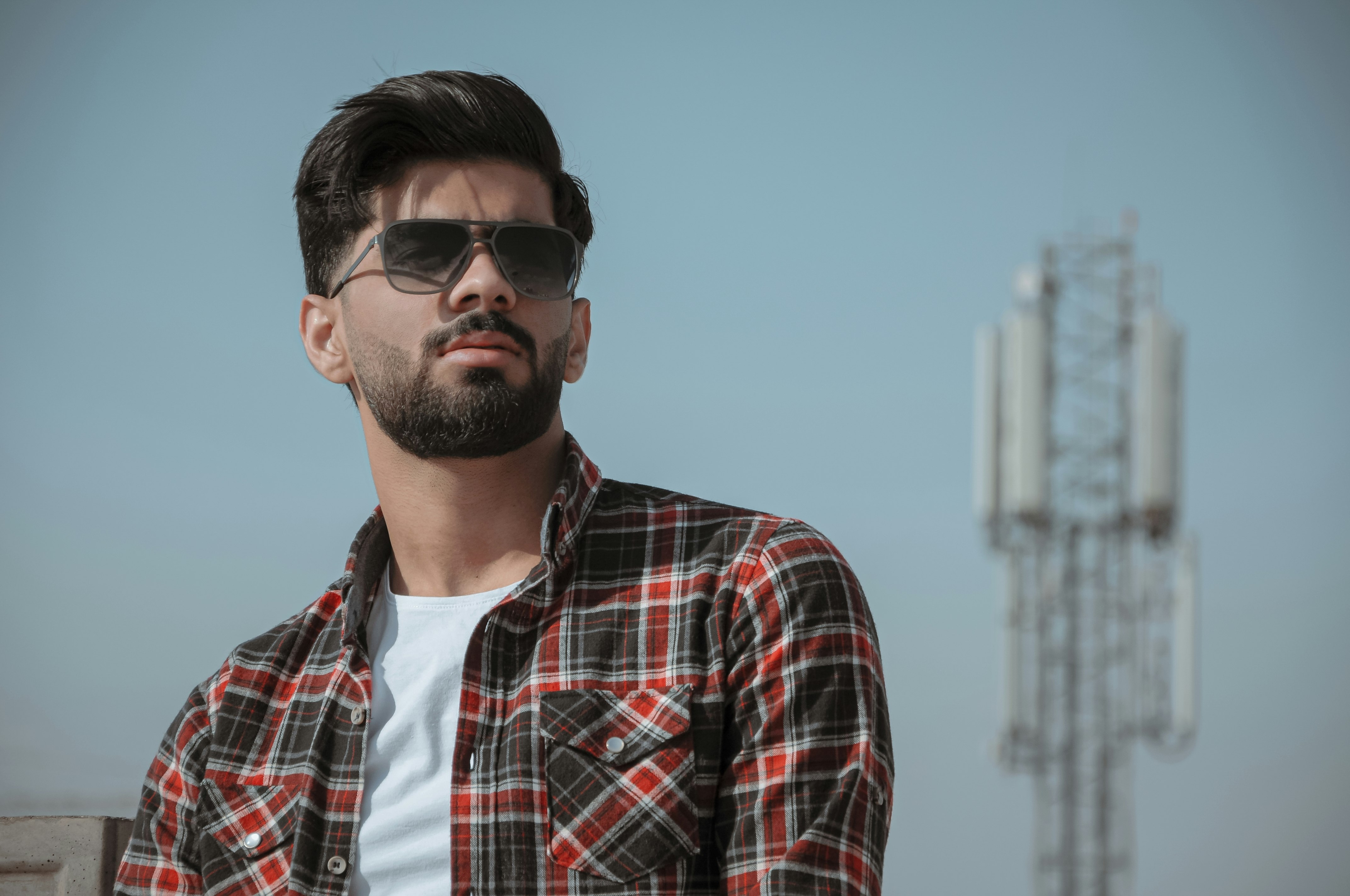 man in red white and blue plaid button up shirt wearing black sunglasses